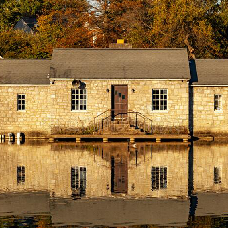 river-house A Stone building reflected on the face of a body of water